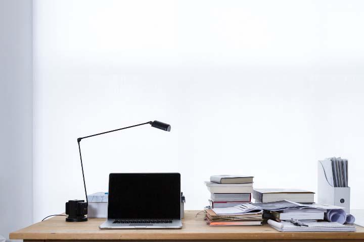 A clean office table with books and a laptop